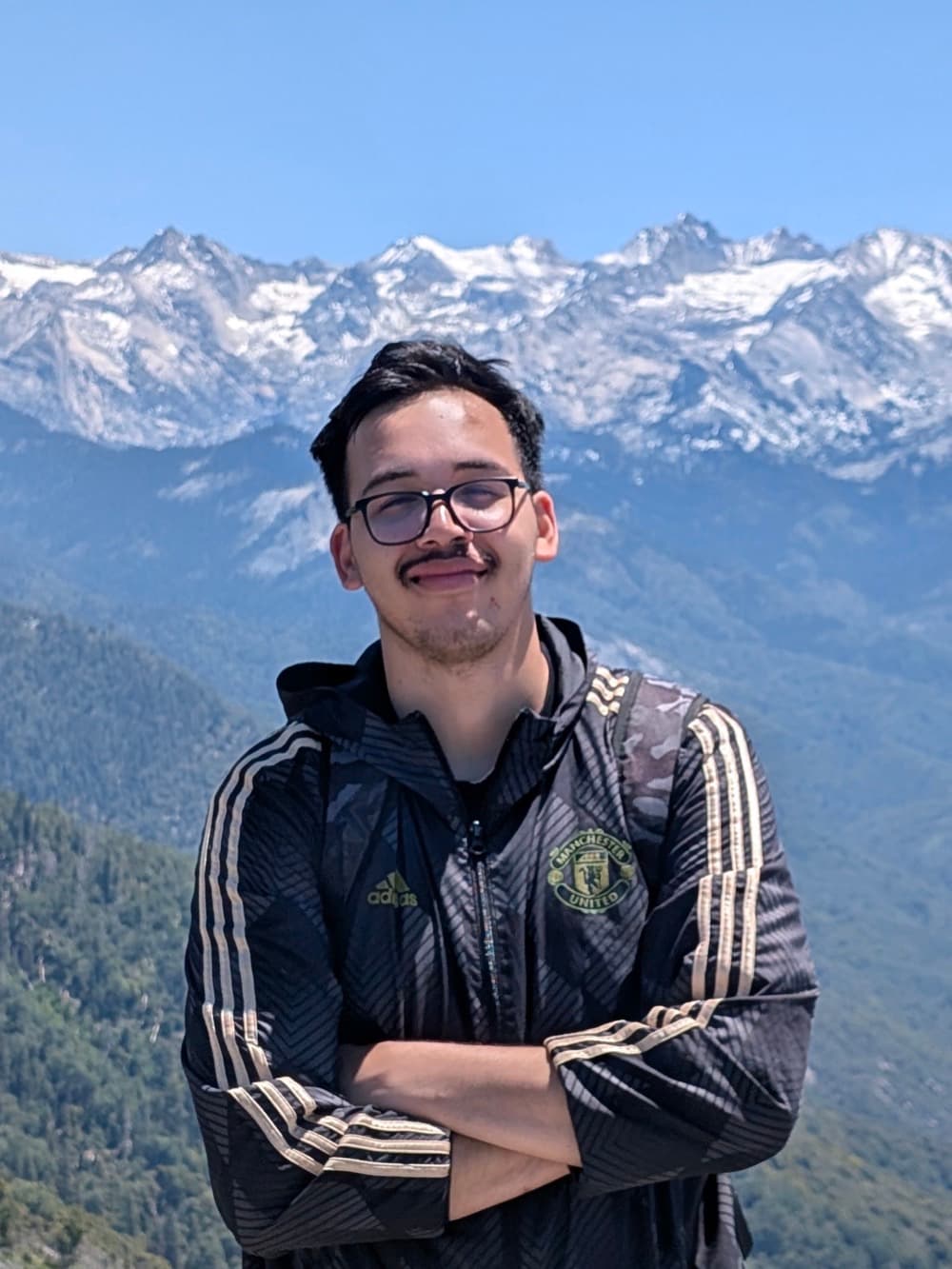Aryan Tandon standing in front of the snow-capped Sierra Nevada in Sequoia National Park